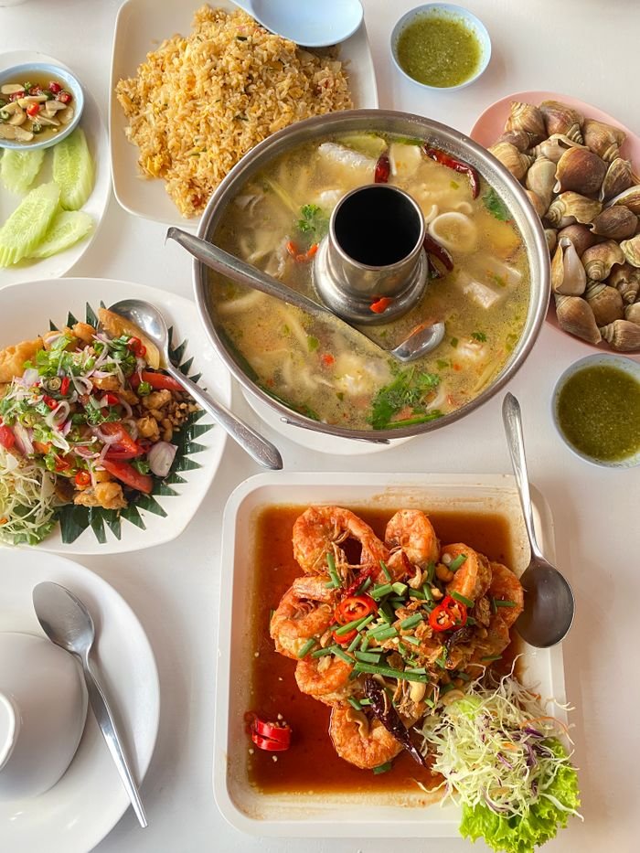 A vibrant spread of traditional Thai dishes including Tom Yum soup, fried rice, seafood and spicy salads.